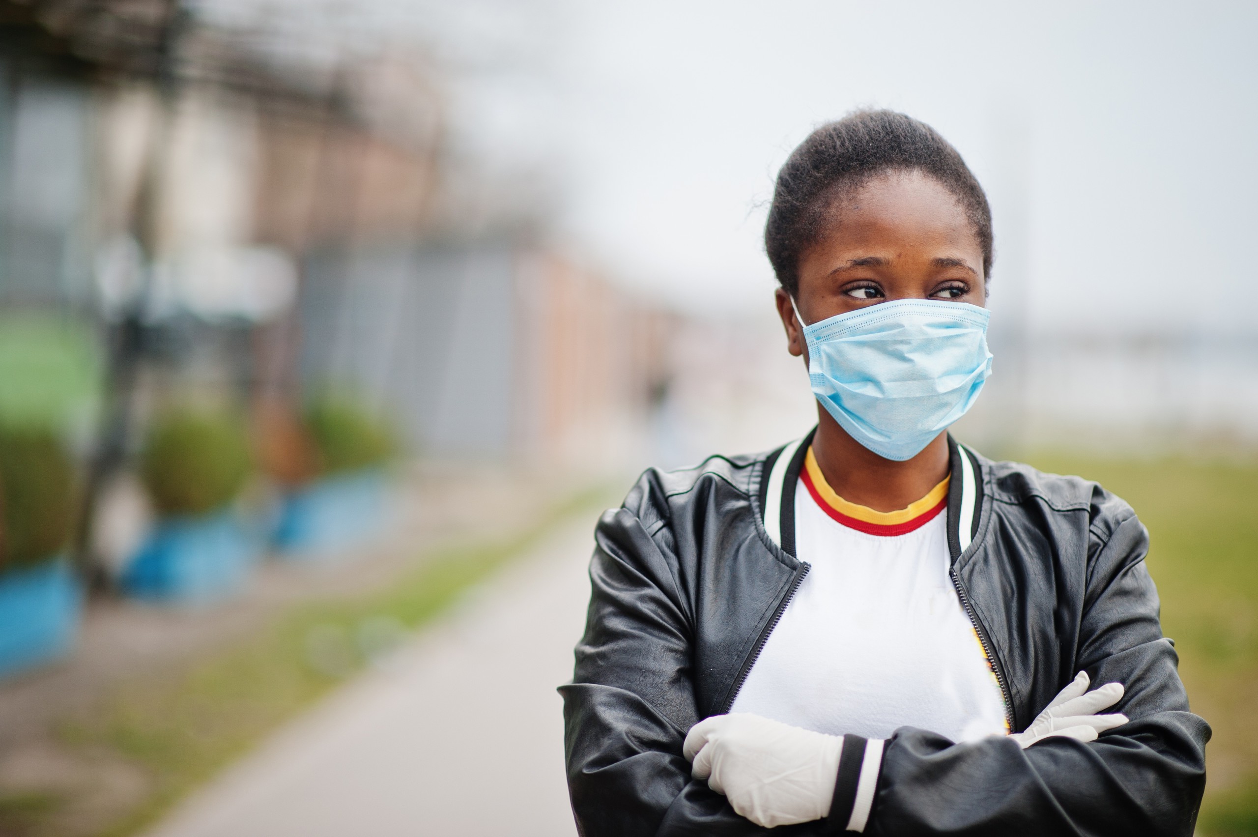 African girl at a local park wearing a medical mask to protect her from COVID-19 and environmental pollution.