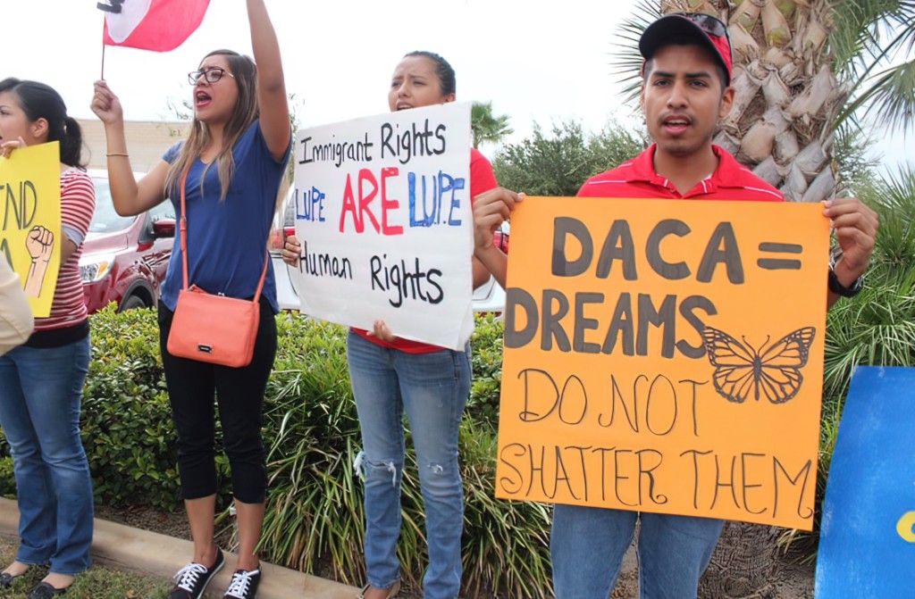 Students holding up signs that read ‘DACA=Dreams, Don’t Shatter Them’ and ‘Immigrant Rights are Human Rights.’
