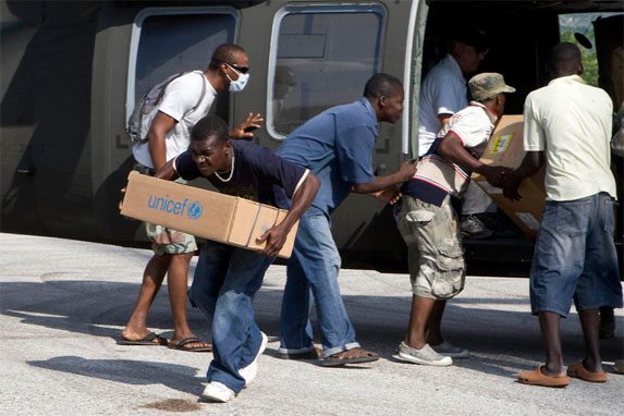 Haitian volunteers unload a U.S. helicopter carrying supplies for earthquake victims in Jacmel, Haiti