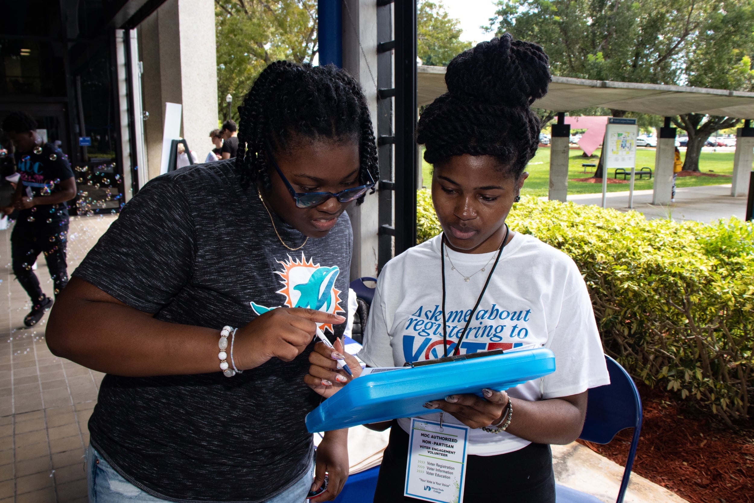 A volunteer from Engage Miami helping community members register to vote.
