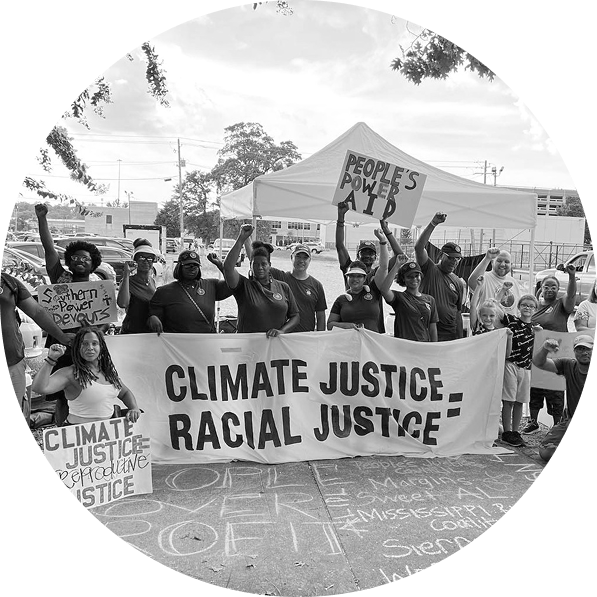 Protesters with GASP hold bold signs and banners linking climate, racial, and reproductive justice, amplifying calls for systemic change through grassroots organizing in the South.
