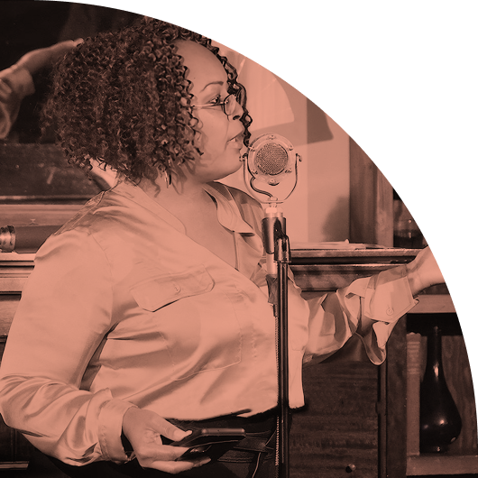 Black woman speaking confidently at a microphone to engage supporters for Tides nonprofit initiatives.