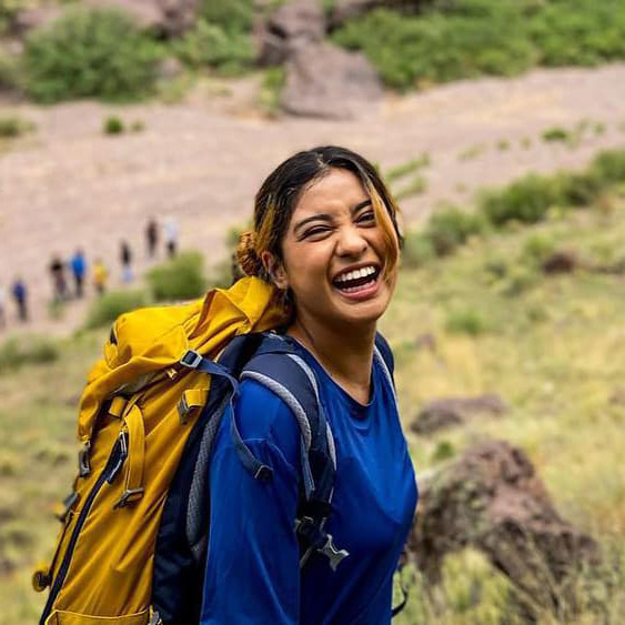 A group of youth backpacking with the Semilla Project; a young Latine woman smiles in the foreground.