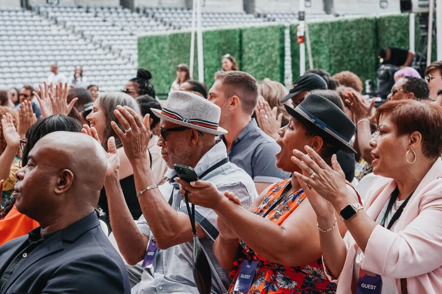 A multiracial and gender diverse crowd clapping at the WWAV Culture of Democracy Summit.