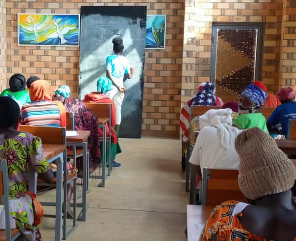 A teacher writes on the blackboard in a classroom in Rwanda. Photo credit: Kate Spade, a donor advised fund at Tides