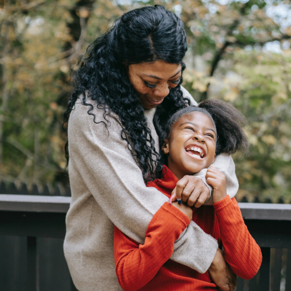 A Black mother and daughter embracing