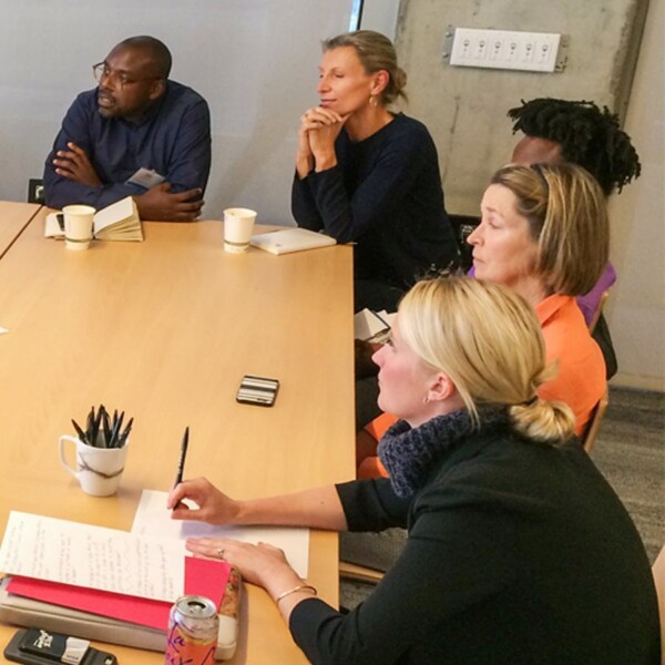 A multiracial and gender-diverse group of people meeting in Google's Community Space.