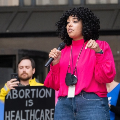 A Black woman speaks at a reproductive justice event.
