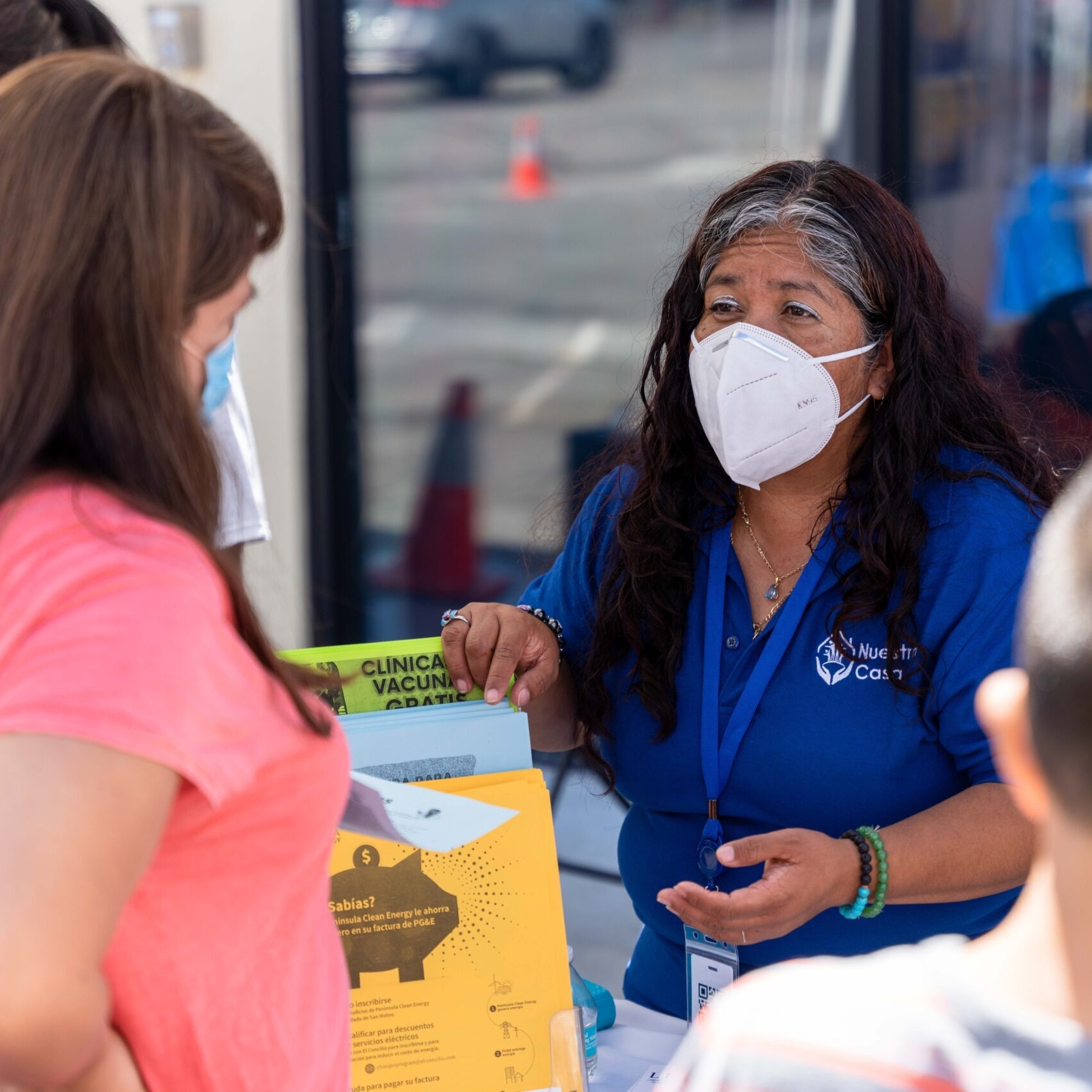 Two women wearing masks discussing community issues at a community event. Photo Credit: Nuestra Casa, The Victor & Lorraine Honig Initiative Awardee 2023
