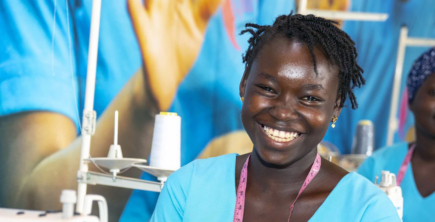 A young Black woman at a sewing station.
