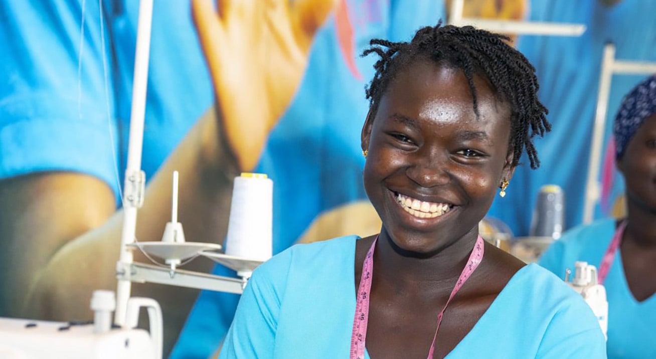 A young Black woman at a sewing station.