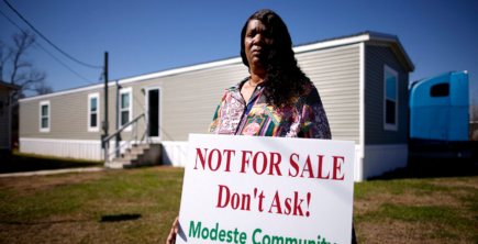 Twila Collins, a Modeste community member in Ascension Parish, Louisiana, holds a sign that reads “Not for Sale. Don’t Ask! – Modeste Community.”