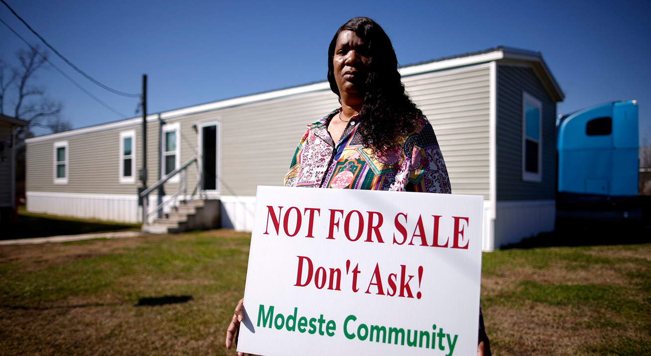 Twila Collins, a Modeste community member in Ascension Parish, Louisiana, holds a sign that reads “Not for Sale. Don’t Ask! – Modeste Community.”